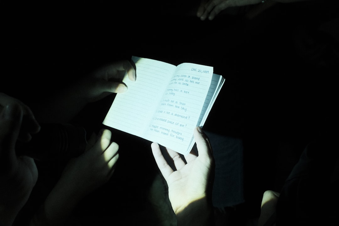A person reading a book in the dark